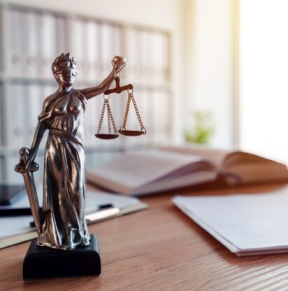 Lady Justice statue in law firm attorney office, blindfolded Justitia with balance scales and sword is personification of moral force in judicial system